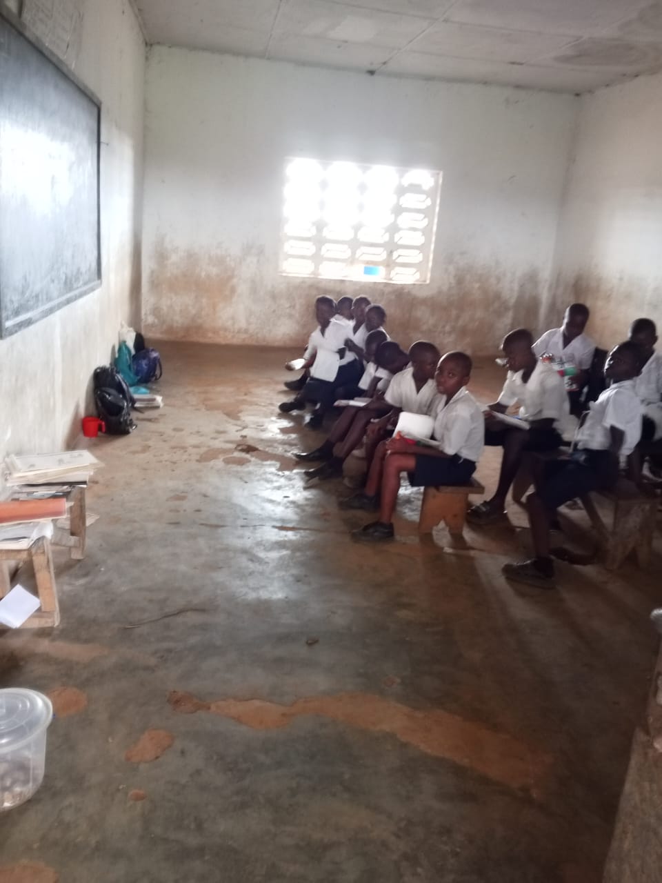 Students seated in a deteriorating classroom
